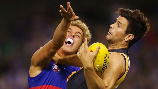 Trent Cotchin holds off Bulldog Mitch Wallis to take a one-handed mark.