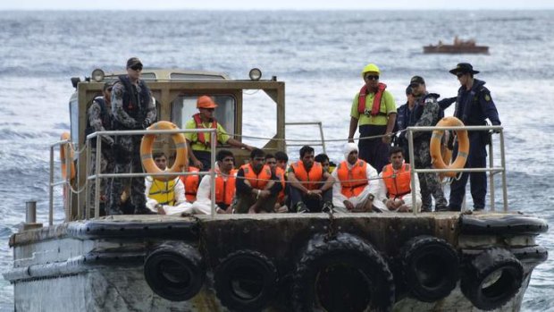 Australian customs officials and navy personnel escort asylum-seekers to Christmas Island in August, 2013. The UN says forcing boats back to Indonesia may breach international law.