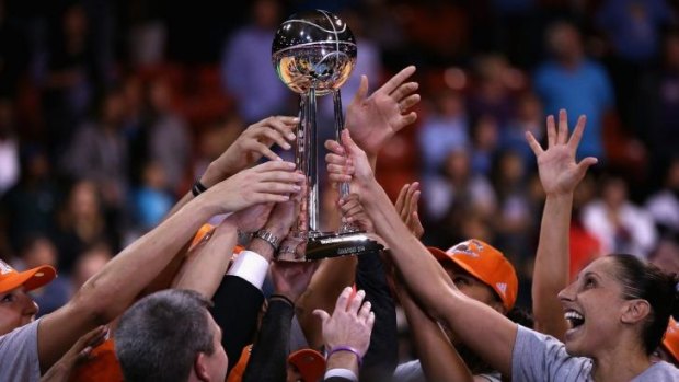 Group effort: The Phoenix Mercury hold the WNBA championship trophy.