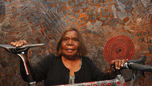 Artist Wentja Napaltjarri with one of three carbon-fibre bicycles that have been painted by indigenous artists. They will be auctioned this Friday to raise funds for the Bikes for Bush program.