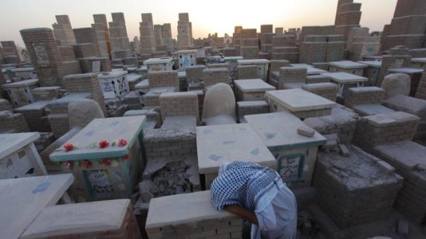 A man grieves at a cemetery in Najaf, south of Baghdad on Monday.