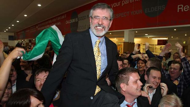 Carried away ... Sinn Fein's president, Gerry Adams, is lifted on to the shoulders of  supporters after winning a seat in the Irish parliament.