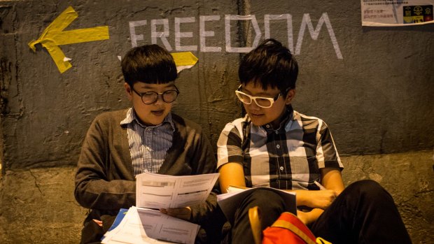 Two university students study accounting on the street outside Hong Kong's government complex on Wednesday.