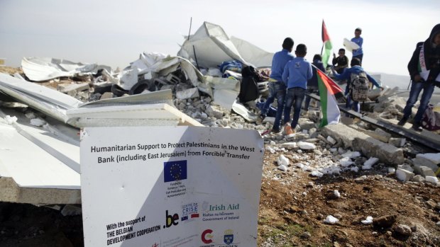 Bedouin children stand amid the rubble of two classrooms demolished by Israeli authorities in the village of Abu Nuwar.