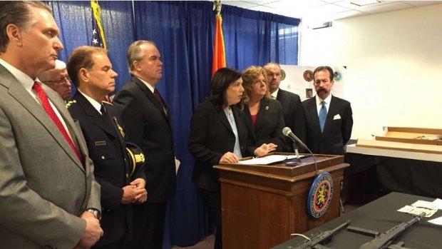 Acting District Attorney Madeline Singas (centre) at a press conference with a variety of weapons on display.