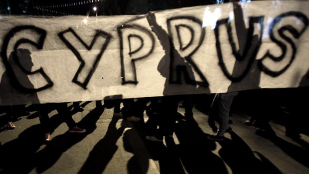 Euro zone crisis ... protesters hold a banner during an anti- bailout rally outside of European Union house in capital Nicosia, Cyprus.