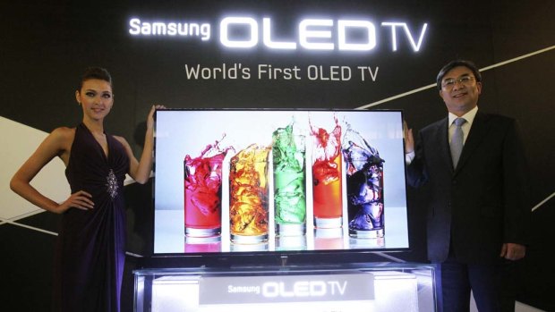 Kim Hyun-suk, head of Samsung's TV business, right, and a model pose with a 55-inch Samsung OLED TV at the launch.