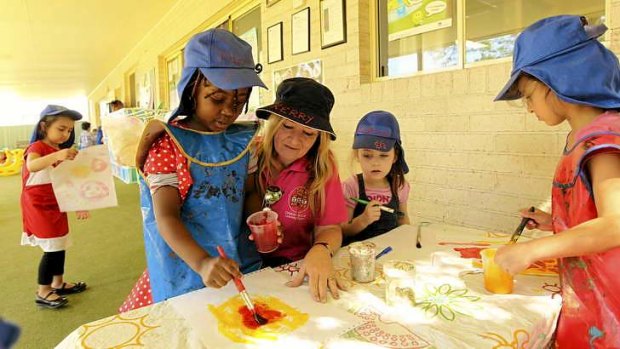 Picture perfect: Children join in an art activity at the Clovel centre in Merrylands with childcare worker Kerry Elias.