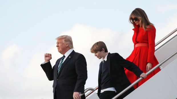 President Donald Trump with his wife first lady Melania Trump and their son Barron, pumps his fist as they disembark from Air Force One on Friday.