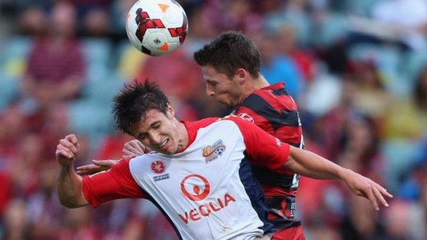 Michael Marrone of Adelaide United and Shannon Cole of the Wanderers compete for the ball.