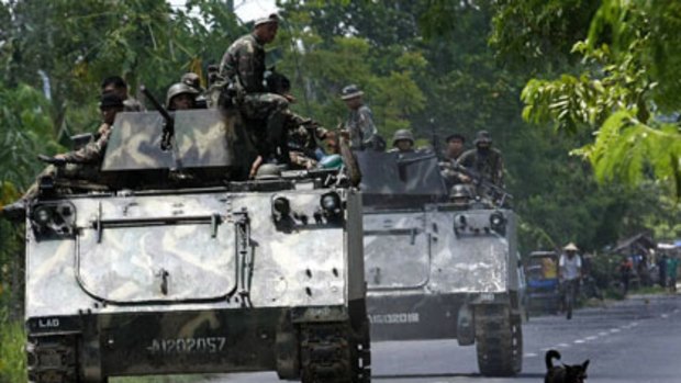 Philippine Army armoured personnel carriers and trucks move down a highway of the town of Datu Piang in Maguindanao on military actions against separatist rebels.