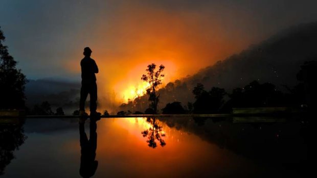 The award-winning photograph by Justin McManus of Justin Crawley monitoring the Harreitville fire that threatened his property.