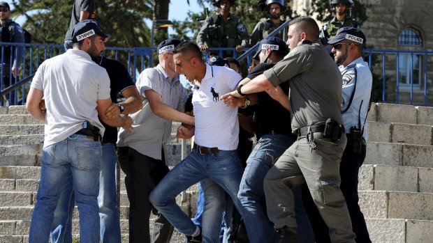 Israeli police officers scuffle with a Palestinian protester during a march marking Jerusalem Day. 