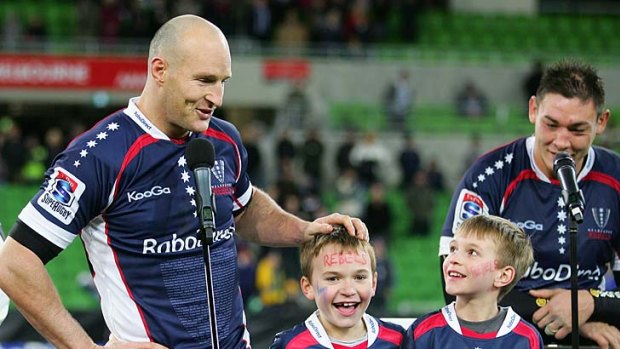 Stirling Mortlock gets ready to make his farewell speech after the game, as his children look on.