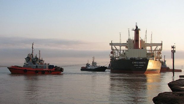 A tugboat pulls a ship at Port Hedland. Tug engineers have called off their strike.