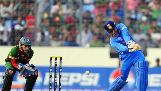 Virender Sehwag advances down the wicket to drive.