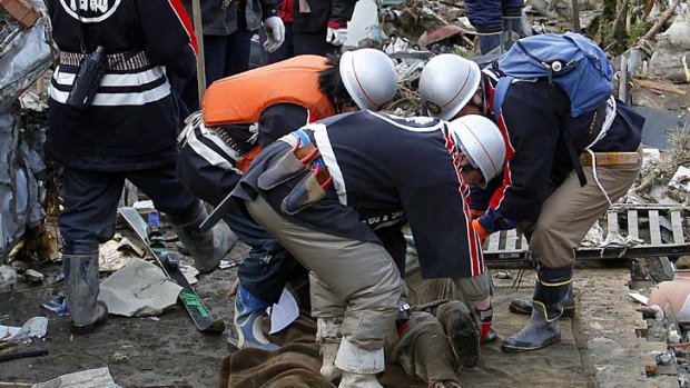 Desperate attempts . . . rescue workers in Rikuzentakata.