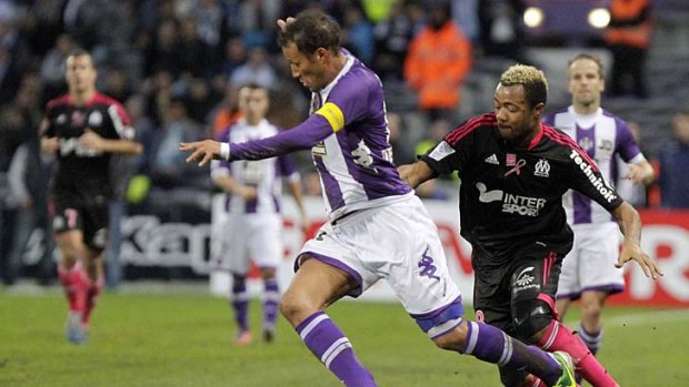 Olympique Marseille's Jordan Ayew (right) chases Jonathan Zebina of Toulouse.