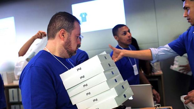 Redy for work ...: Apple employees carry boxes of new iPads that went on sale for the first time around the world last week.