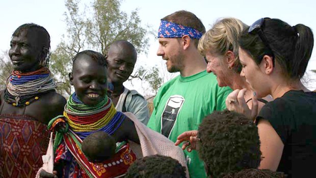 Rod Schneider and other participants Raye and Raquel talk to a Turkana mother and child in Kakuma Refugee Camp, Kenya.