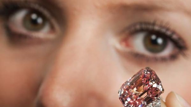 An employee poses with a 24.78 carat Fancy Intense Pink diamond at Sotheby's in Geneva November 10, 2010.