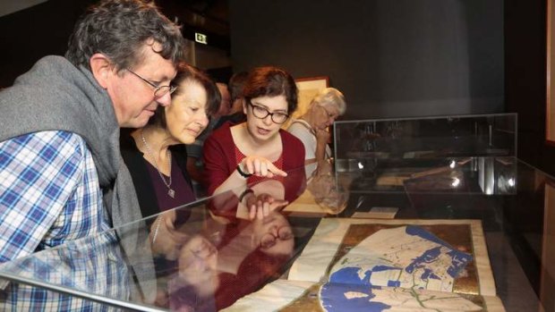 Duncan McLay and Neryl McLay from the Gold Coast are show a world map in Geographia by Claudius Ptolemy by Mapping the World co-curator Susannah Helman.