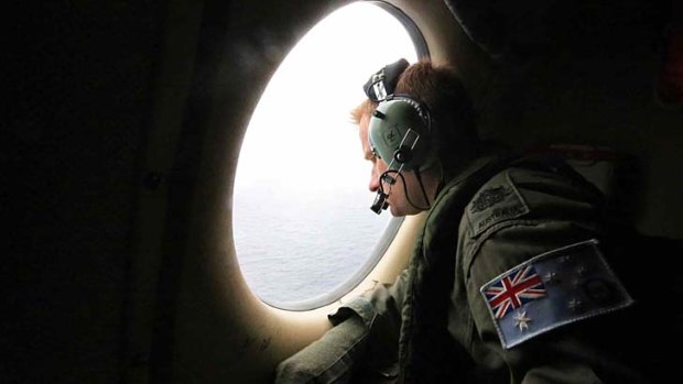 Short window in debris hunt: A Royal Australian Air Force officer looks out of an aircraft window as it flies over the southern Indian Ocean during the search for the missing plane.