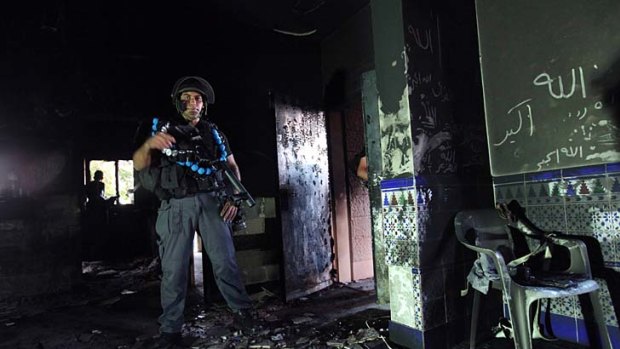 An Israeli police officer at a burnt mosque in Tuba-Zanghariya.
