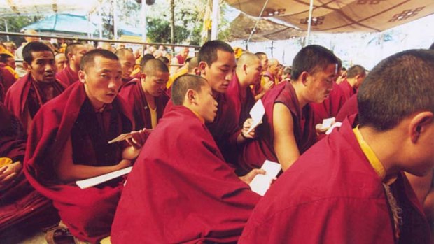 Monks chant prayers before the beginning of the day's teachings from the Dalai Lama.