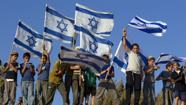 Young Israelis hold the national flag in support of Jewish settlements in the Israeli occupied Palestinian West Bank.