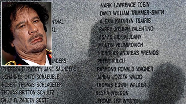 Shadows are cast on the memorial stone for the victims of Lockerbie bombing in Lockerbie and, inset, Gaddafi.