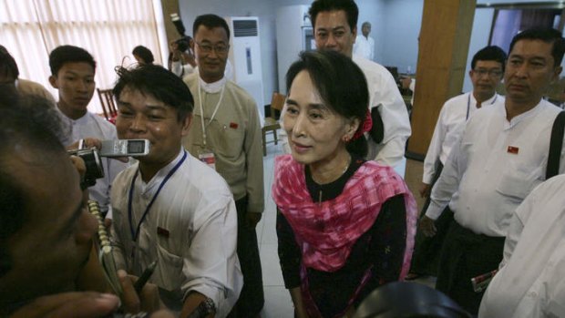Myanmar Opposition Leader Aung San Suu Kyi, center, talks to journalists as she attends Central Executive Committee meeting of her National League for Democracy party at a restaurant in Yangon, Myanmar, May, 2013.