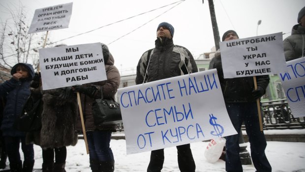 Protesters hold placards during a picket in central Moscow. The people, who took mortgages in foreign currencies, now face larger risks due to the weakening of the rouble. 