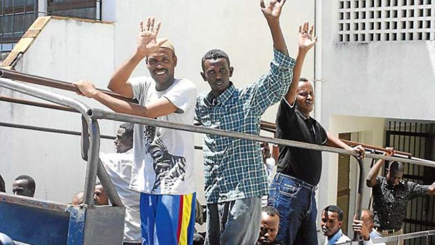Suspected pirates gesture as they leave court in Kenya on Tuesday, November 9, 2010. A judge freed them because their alleged raid took place off the Somali coast outside Kenyan jurisdiction.