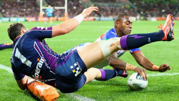 Try time: Akuila Uate bumps off Billy Slater to score against the Storm.
