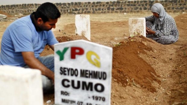 Rabia Mustafa Ali, right, and a relative mourn at the grave of her son Seydo Mehmud Cumo, a fighter with the Kurdish YPG militia killed in the fighting for Kobane. The cemetery is near the Turkish town of Suruc.