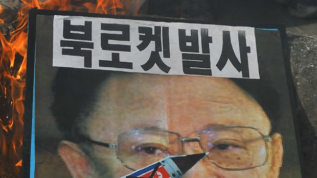 Conservative activists burn a model of a North Korean missile and portraits of North Korean leader Kim Jong-Il.