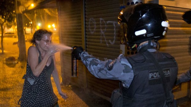 Confronting: A policeman sprays a protester during a demonstration in Rio de Janeiro.