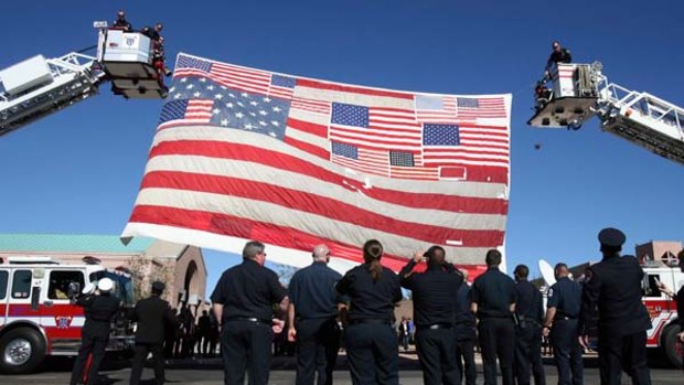 Young life lost ... a flag recovered from Ground Zero in New York is flown at the funeral of Christina-Taylor Green in Tucson.