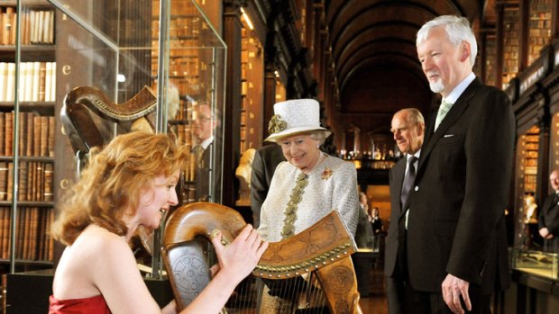 The Queen listens to harpist Siobhan Armstrong during a visit to Trinity College in Dublin.