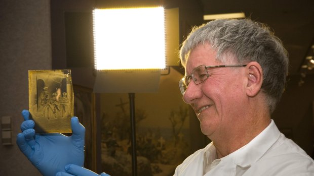 Australian War Memorial senior photographs conservator, Ian Fulton, with one of 800 fragile glass plates from the "Lost diggers of Vignacourt' collection, a trove of WWI photos discovered after nearly 100 years in the attic of a disused French barn.