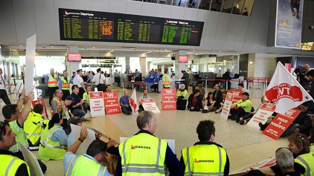 Chaos ... Qantas engineers and groundstaff  conduct a silent sit-in at the airline's domestic terminal at Melbourne Airport.