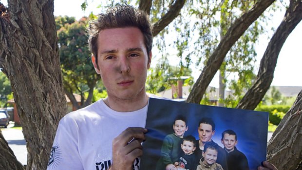 Grief-stricken: Tim's brother, Nathan, holds a fmaily portrait with Tim pictured upper left.