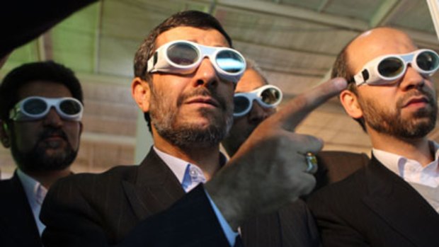 Giving them the finger ... the Iranian President, Mahmoud Ahmadinejad, at a laser exhibition on Sunday, appears to have reneged on a UN-drafted nuclear deal.