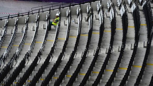A worker takes a break during the clean-up operation at the London 2012 Olympic stadium.