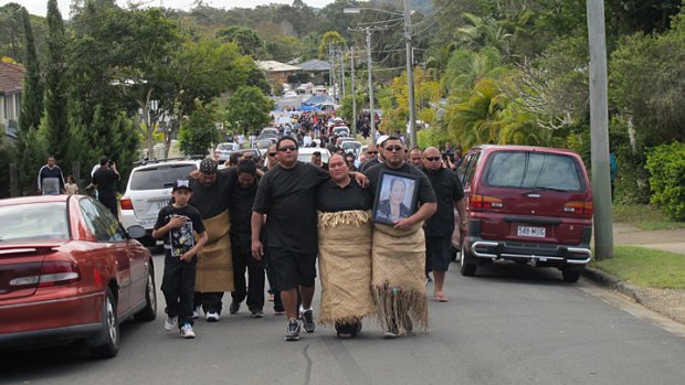 Treicee Taufa (centre), who lost her daughter, mother, sister and eight other family members in the fire, leads a procession in front of a hearse as the final two bodies are taken from the house.