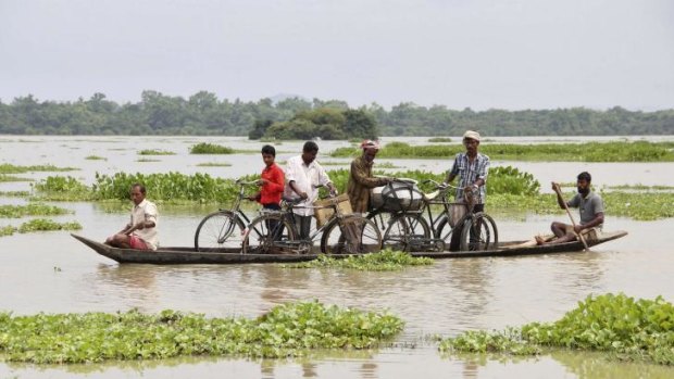 Villagers transport their bicycles on a boat through the flooded areas of Morigaon district in the north-eastern Indian state of Assam on Monday.