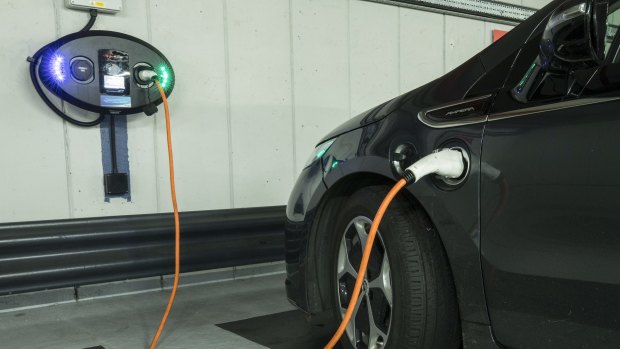 A charging plugs connects an electric vehicle (EV) to a charging station at Q-Park Park Lane underground parking lot in London.