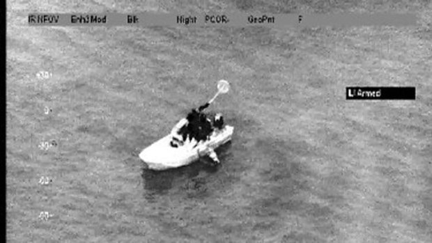 A still image from the police helicopter camera. The missing man is in the water next to the boat.