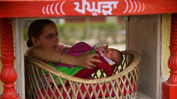 A woman looks after a baby girl who was left in a wicker basket at the Red Cross headquarters in the north Indian city of Amritsar.